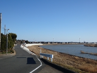 青い空と穏やかな水面、国安海岸まで続く土手道の写真