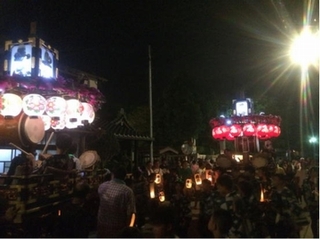 夜祭りの風景。2台のねりの提灯のあかりの赤と白のコントラストが美しい