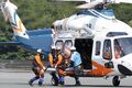 県防災ヘリコプターから救助した人をヘリコプターから県消防防災航空隊の人4人で降ろしている