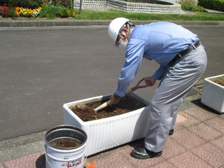 花壇の土の手入れをしている藤澤さんの写真