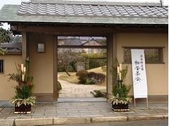 清水邸庭園湧水亭の門前に、門松が飾られ「初釜茶会」の案内看板が立てられている。