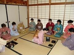 庭園事始めとして恒例の「初釜茶会」の様子。落ち着いた和室の中で、着物を着た女性たちに抹茶が振舞われている。