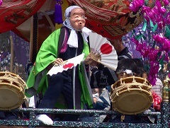 日の丸の扇子を両手に持って踊るひょっとこの手古舞