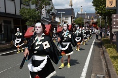 黒繻子の法被を着た奴が練り歩く奴道中の様子