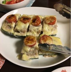 縦に二つに割ったズッキーニにプチトマトを乗せ焼いた料理。食べやすく、一口サイズに切り分けている。