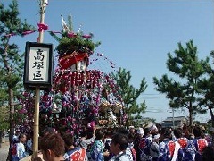 氏子名などを書いた小万度を捧げて山車を曳きまわす人たち