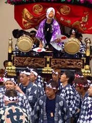 ひょっとこの人形が法被に扇子を持っているせ組（大工町）の祢里