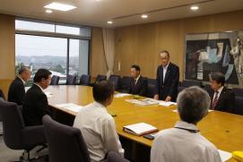 テーブルを囲んでいる松井市長はじめ関係者の方々につま恋リゾート彩の郷の川口会長が立ち上がり挨拶をしている様子