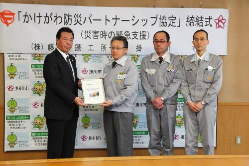 協定締結のための調印式での、市長と株式会社藤田鐵工所の男性社員3名の記念写真