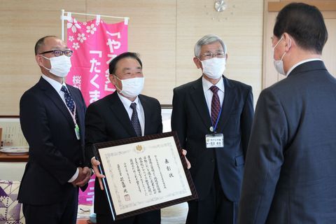松井市長(右)に表彰状を披露し報告する協議会の渡邊会長(左から2番目)ら
