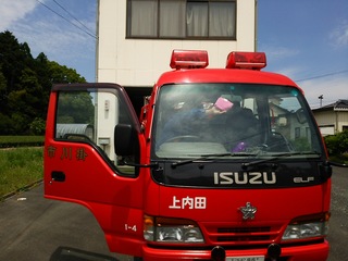 汚れてしまったポンプ車の運転席側からフロントガラスを拭いているのを前から撮影