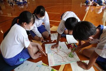 地図上に危険な場所などを書き込む生徒ら