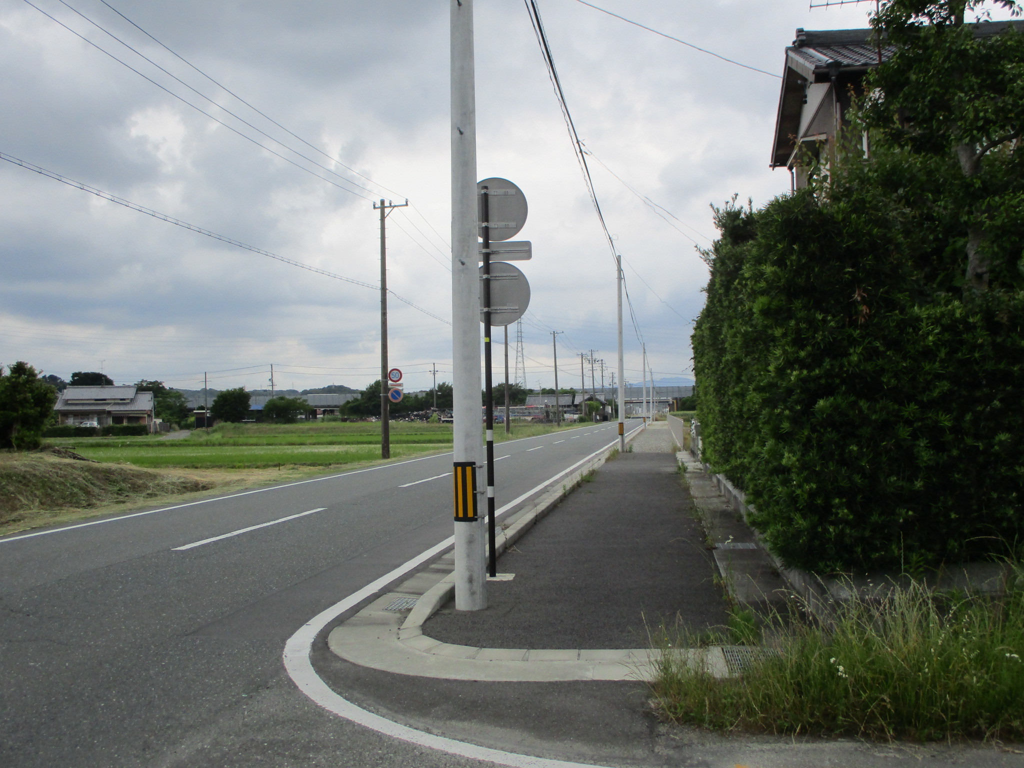 市道「梅橋吉岡線（各和地内）」施工後の道路、歩道の幅が広がり縁石ブロックが設置された