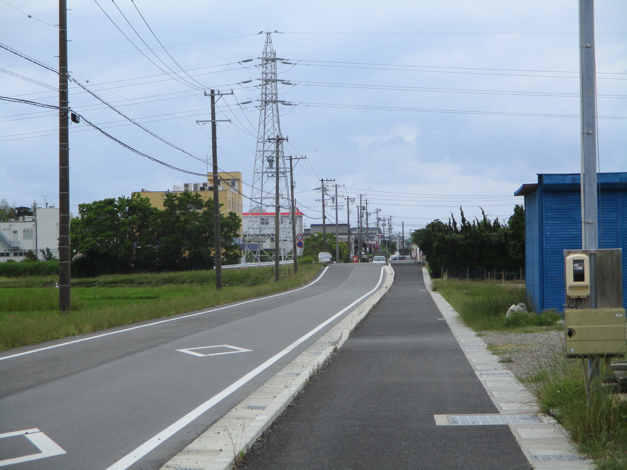 市道「新川西線（東大坂地内）」施工後の道路、縁石で車道と歩道の境が作られた。歩道の道幅も広くなっている