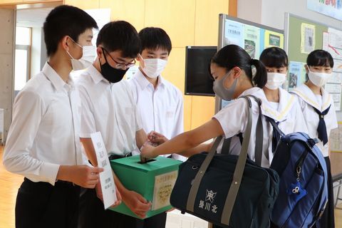 昇降口で募金活動を行う生徒会メンバー