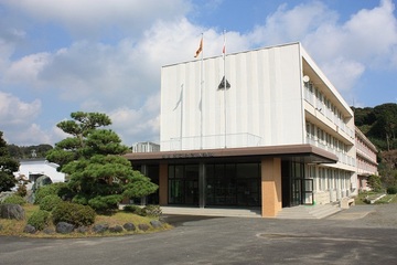 土方小学校の外観。3階建ての校舎と玄関前の植木の様子。