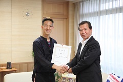 松井市長と固く手を結ぶ輝くかけがわ応援大使委嘱式の写真