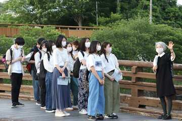 まちづくり実践者(右)から中心市街地の説明を受ける学生