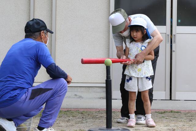 地域住民から打ち方を教わる園児