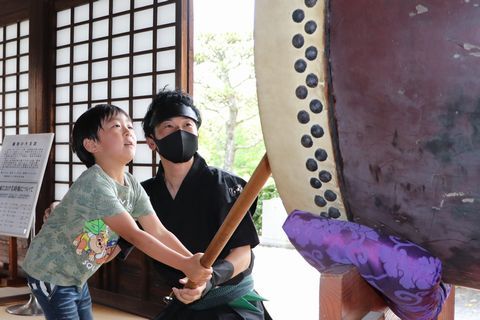 おもてなし隊と大太鼓を打ち鳴らす園児