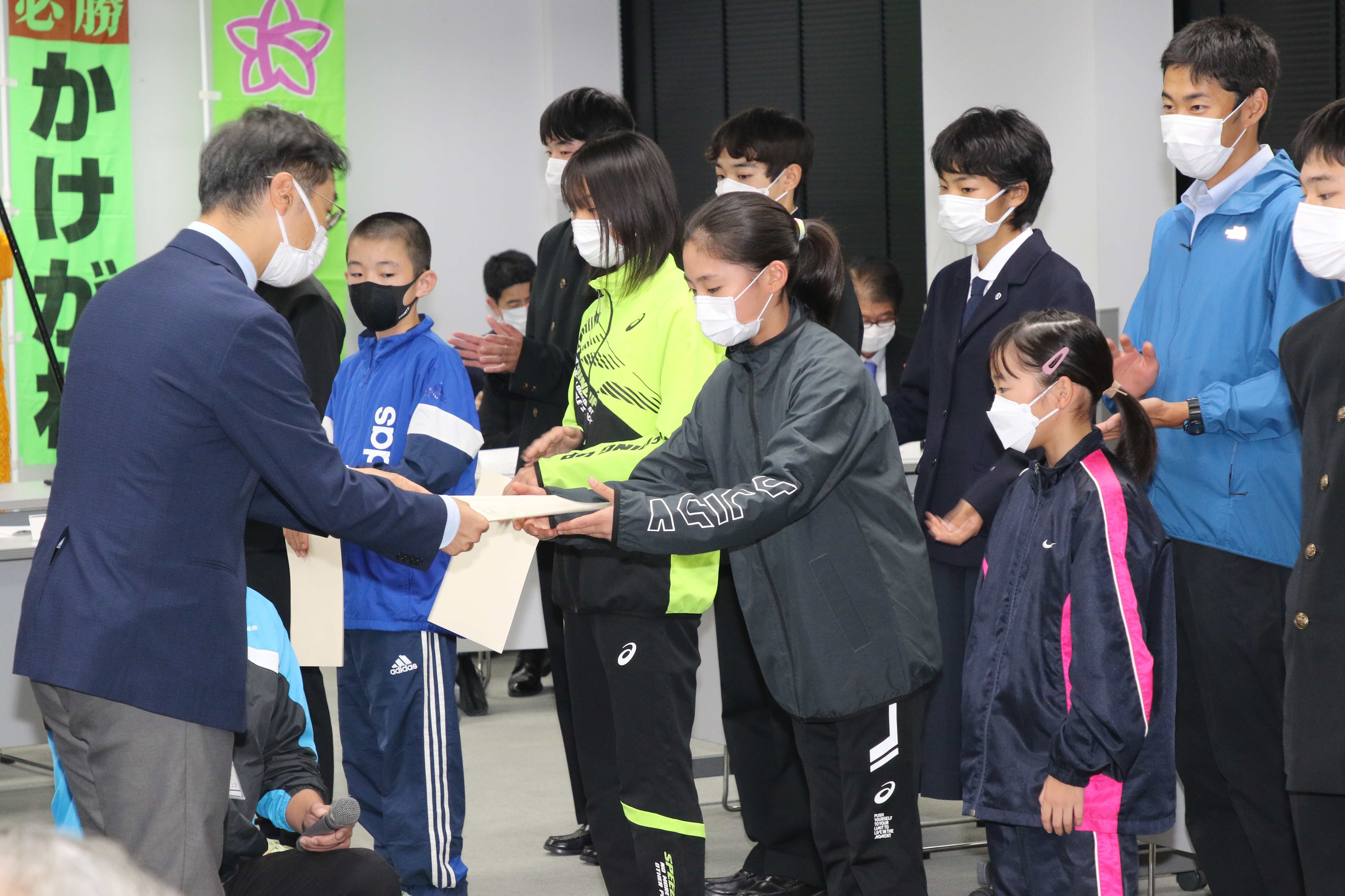 久保田団長（左）から委嘱書を受け取る選手