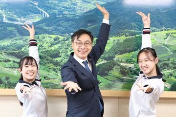 笑顔でポーズをとる選手と久保田市長