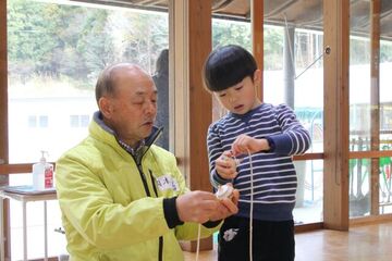 ひもの巻き方を教わる園児