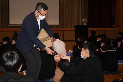 受験生へお茶を配る堀井さん(中央)