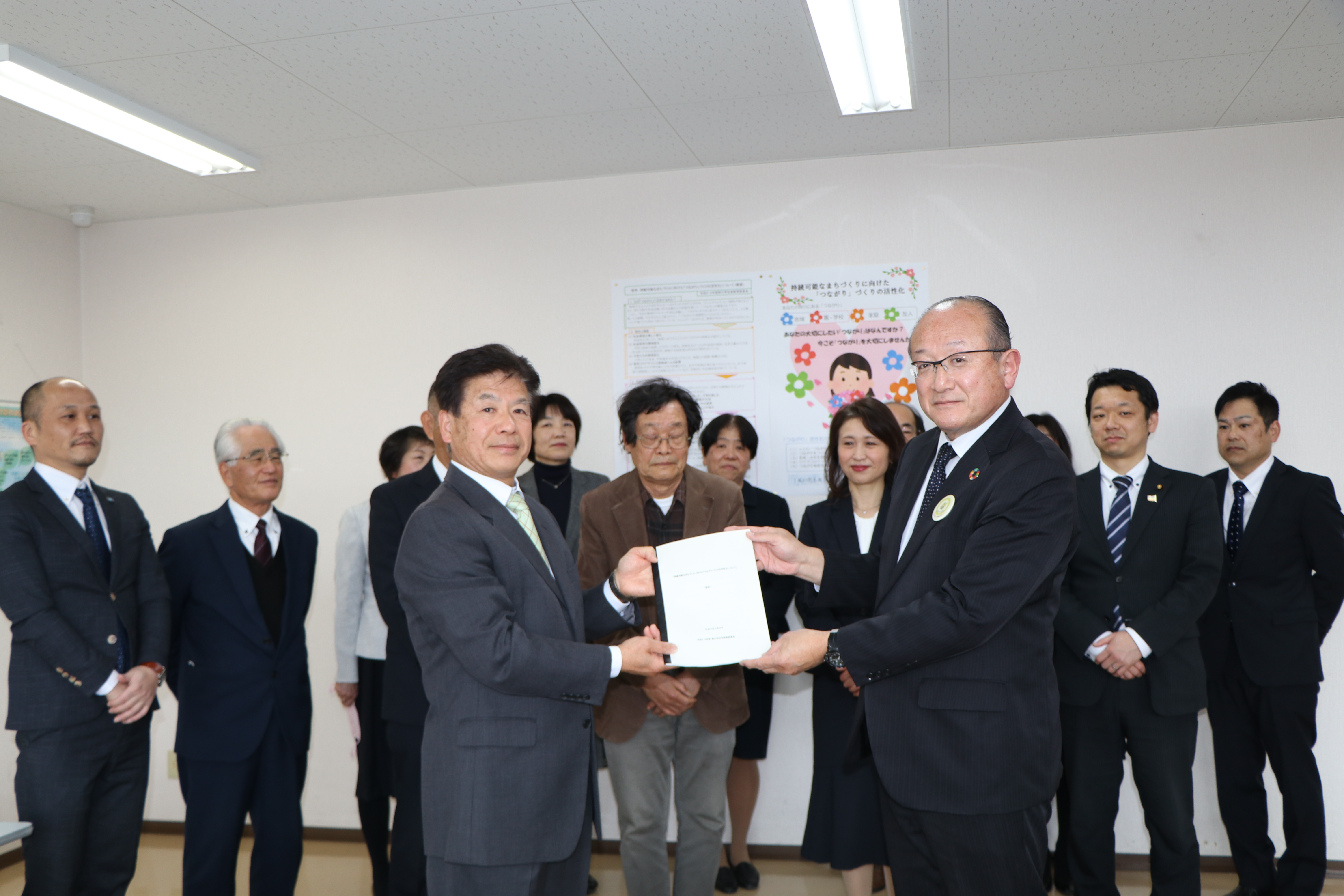 社会教育委員の代表者から教育委員会へ調査・研究結果の答申書を手渡している