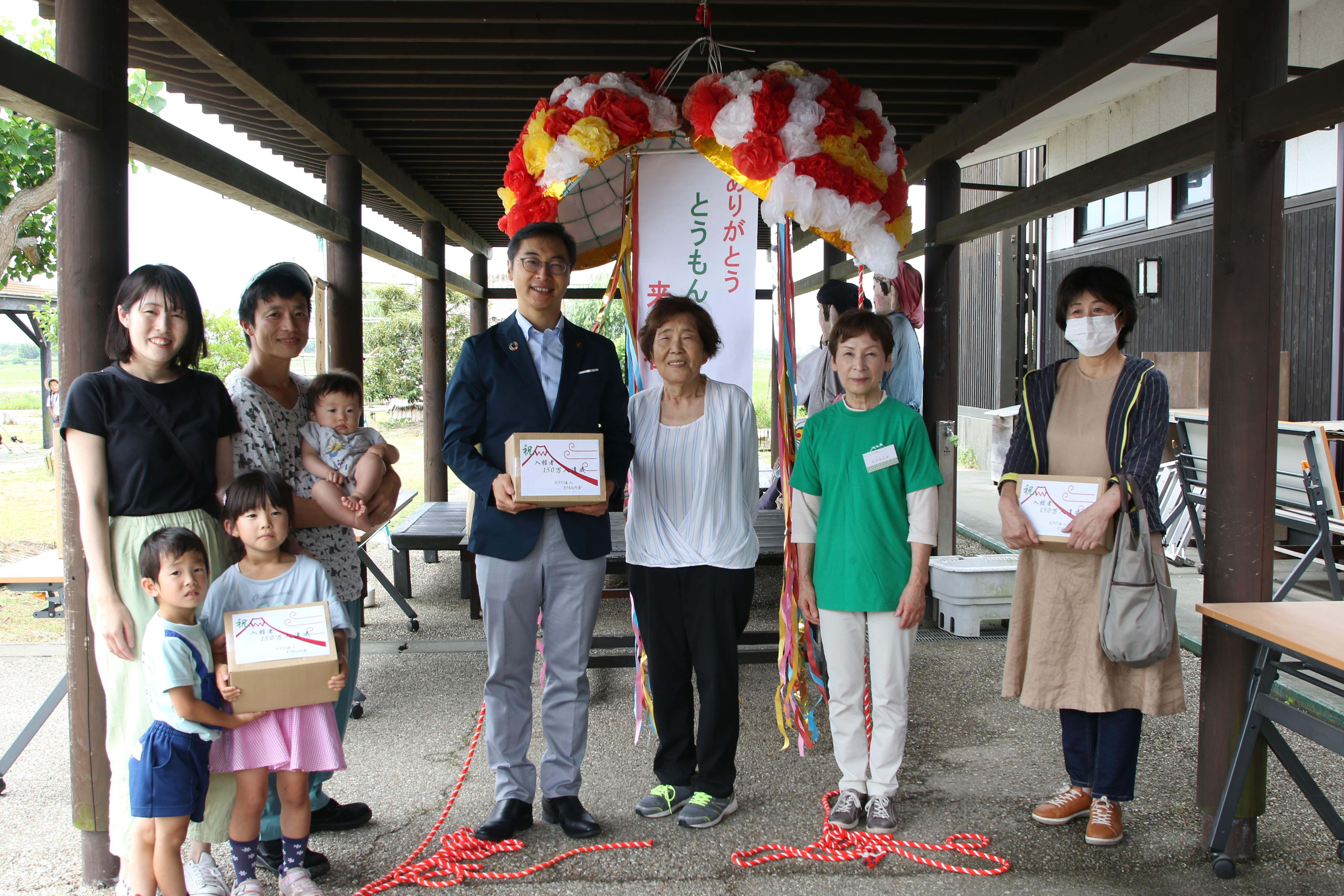 記念品を受け取る来館者たち（中央と左右）と久保田市長（中央左）