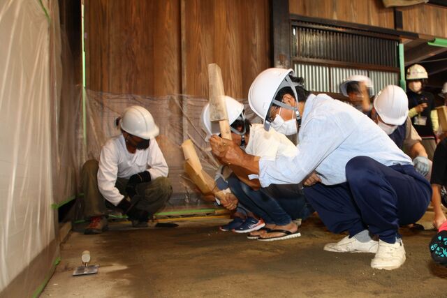 土間の三和土作業を体験する参加者