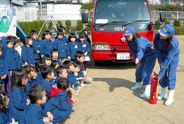 消火器の使い方を子どもたちに指導する女性団員