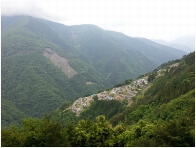 あまの里下栗を空中から撮影した画像で、山の中に小さな集落が見える