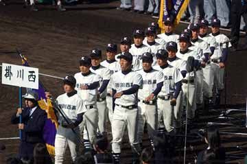 掛川西と書かれたプラカードの後を更新する野球選手たち