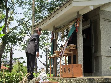 水神宮にて、地鎮祭の様子。お供え物を前に、祈願する男性。