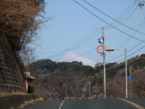 山の上り坂の頂上付近に現れる富士山の写真