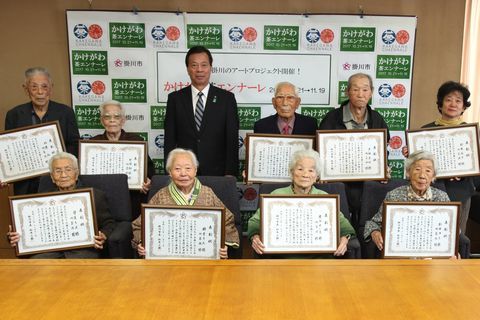 市役所を訪れ松井市長と記念撮影に収まる表彰者たち