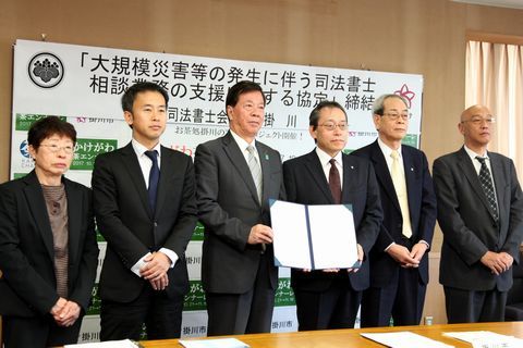 協定を締結した県司法書士会メンバーと松井市長
