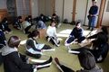 室内で日本赤十字奉仕団のメンバーから三角巾法を学ぶ中学生ら