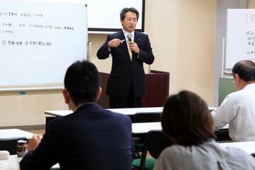 皆の前で事例発表をしている様子