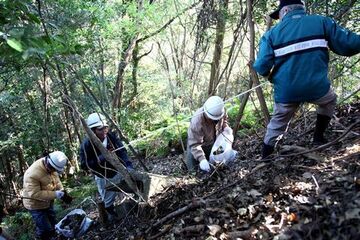 急傾斜地でゴミ拾いをする参加者