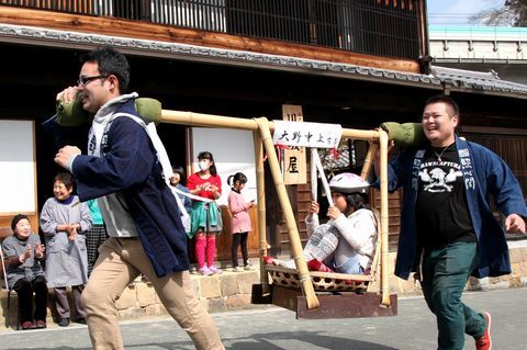駕籠に小学生を乗せ、東海道を駆け抜ける参加者の写真