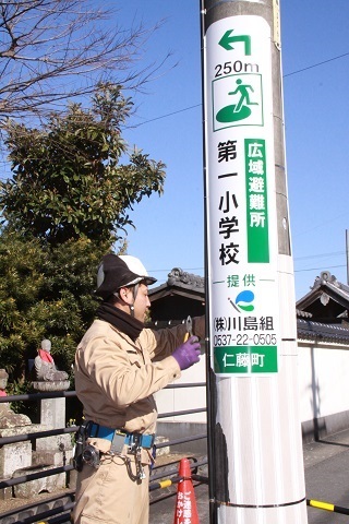 広域避難所、第一小学校まで250メートルとかかれた、最寄りの広域避難所をわかりやすく表示した看板を設置している写真