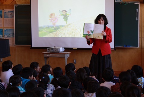 生徒の前に立ち、本を開いて見せている永田さん