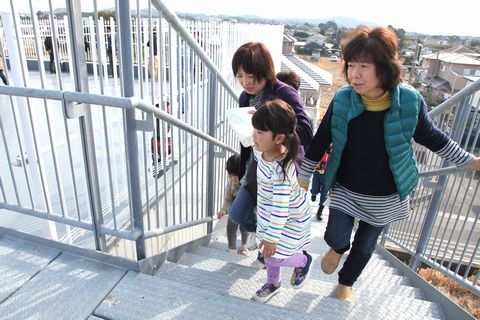 タワーへの階段を上る親子連れ