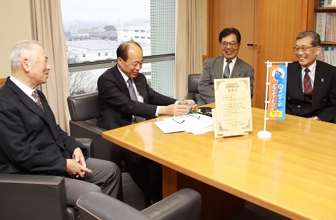 テーブルを囲んで伊村副市長に笑顔で受賞を報告する下西郷長寿会三役会のみなさん