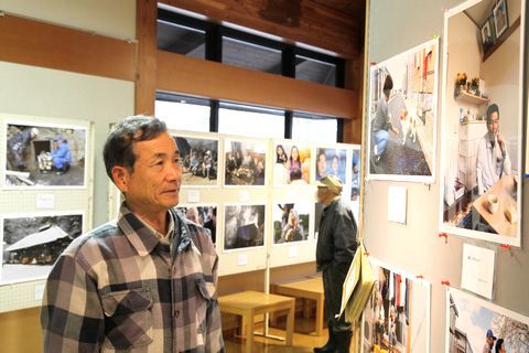 福島県の現状を伝える写真や津波の怖さを伝えるパネルを眺める男性
