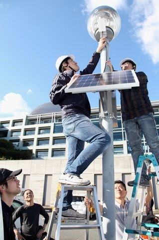 太陽光パネルやLED街路灯を設置する市職員らの写真