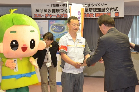 交付式にて、松井市長が三崎千里工場長に認定証を手渡ししている