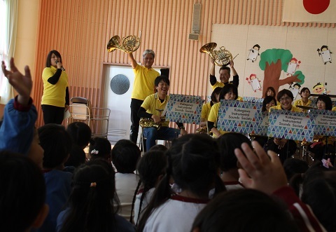 楽器を持ち上げながら紹介をする掛川吹奏楽団